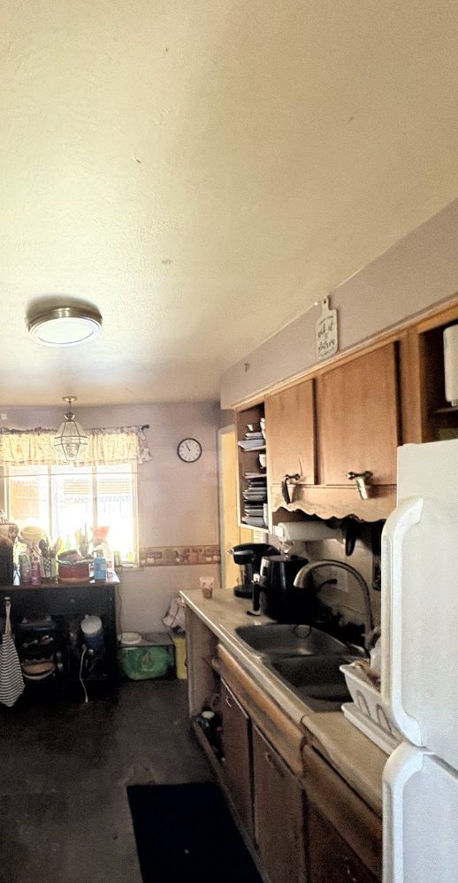 Kitchen packed with belongings and clutter in a Colorado home purchased as-is