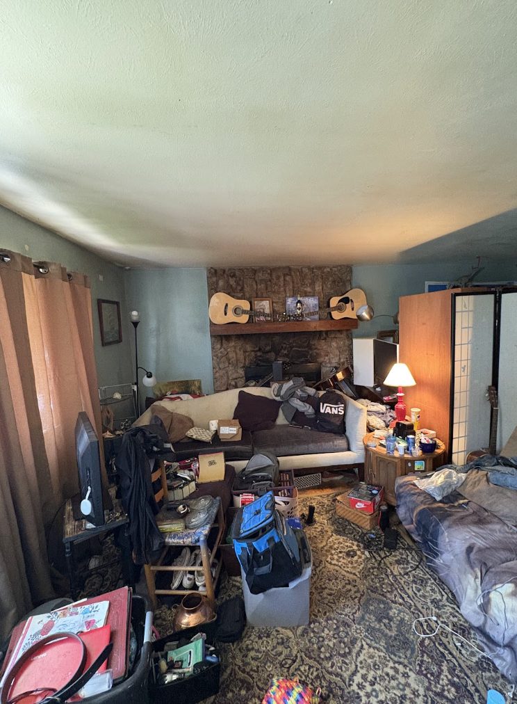Living room of a hoarder house in Lakewood, Colorado, filled floor to ceiling with belongings, before Windcrest Investments purchased it as-is